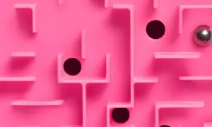 Un labyrinthe rose avec des trous noirs et une bille argentée, évoquant le multi-threading dans la résolution de problèmes complexes.