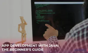 Un homme suit un tutoriel Java sur son écran, avec un mannequin en bois à côté.