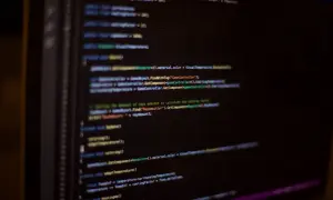 Code C# affiché sur un écran d'ordinateur, avec des lignes de code colorées sur fond noir.