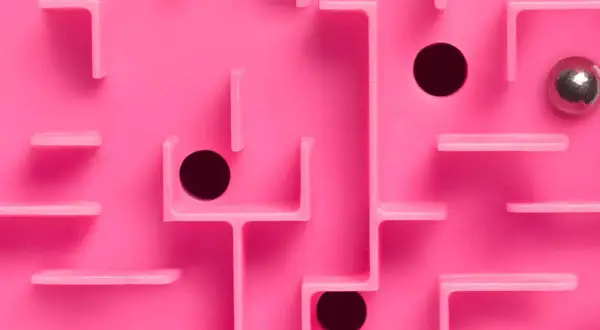 Un labyrinthe rose avec des trous noirs et une bille argentée, évoquant le multi-threading dans la résolution de problèmes complexes.