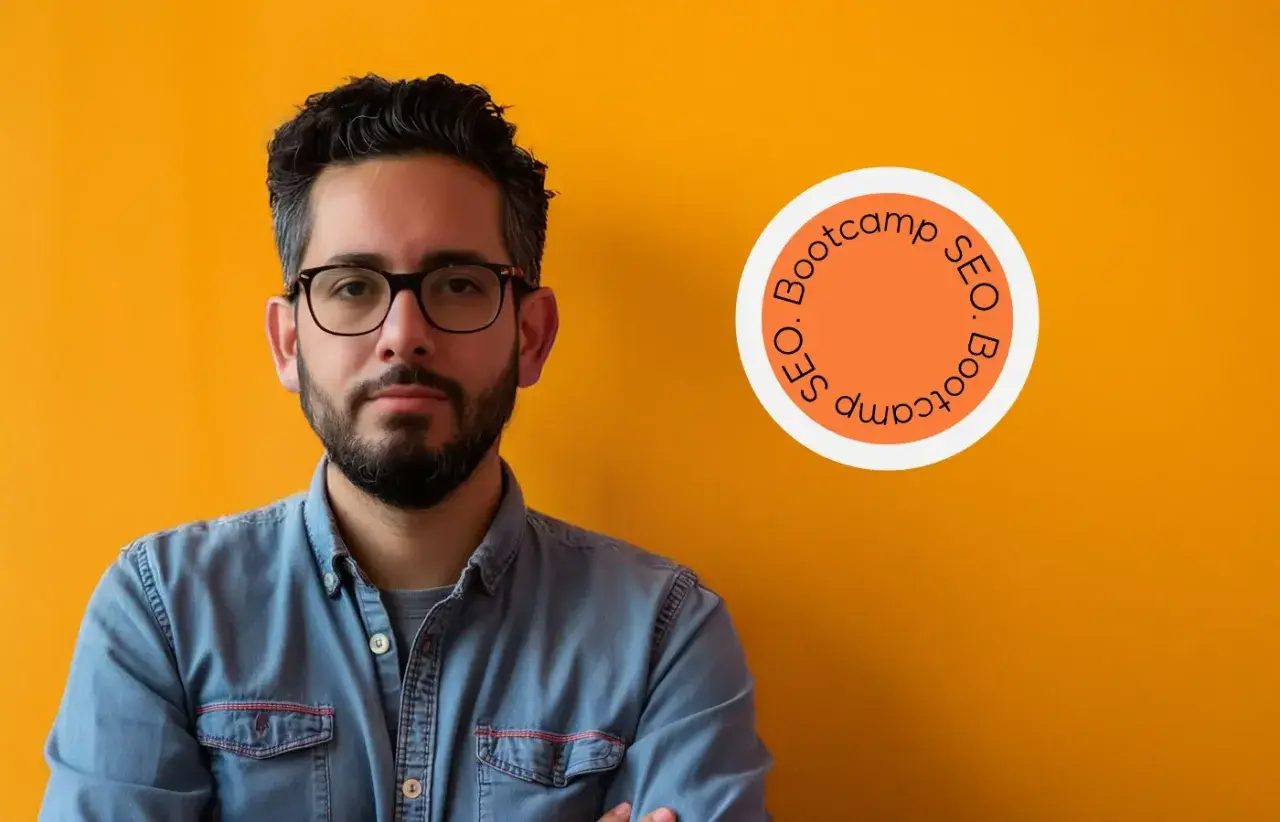 Homme confiant, lunettes, chemise en jean, devant un mur orange. Logo "SEO Bootcamp" suggérant une formation SEO diplômante.