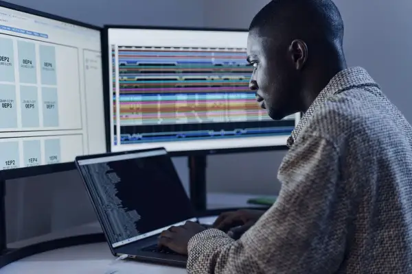 Un développeur analyse des données complexes sur plusieurs écrans, optimisant le code pour le **junit logo**.