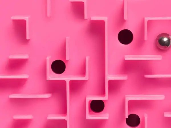 Un labyrinthe rose avec des trous noirs et une bille argentée, évoquant le multi-threading dans la résolution de problèmes complexes.