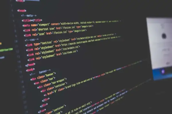 Code informatique affiché sur un écran, avec des lignes de HTML et CSS. Le logiciel Scilab est utilisé pour le développement.